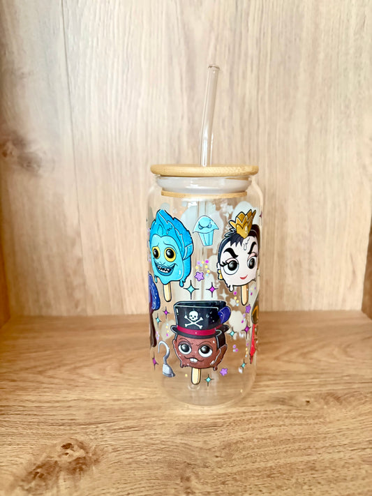 A clear glass tumbler with a bamboo lid and clear straw, decorated with colorful cartoon characters and ice cream cone illustrations, set on a wooden surface against a wooden background.