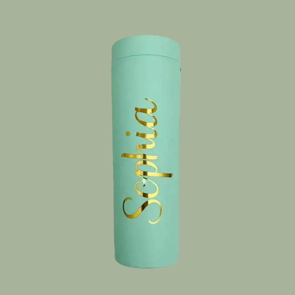 Light blue tumbler with 'Sophia' in gold on a light green background
