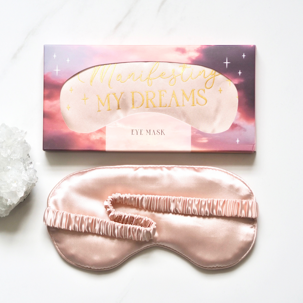 Pink eye mask with 'Manifesting My Dreams' packaging on a white background