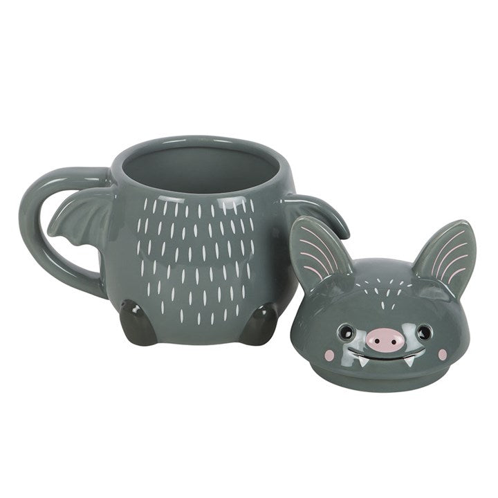Gray bat-shaped mug with a face on a white background