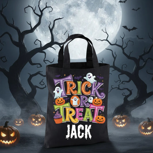 Black tote bag with trick or treat design surrounded by pumpkins, ghosts and cakes on a spooky background. 