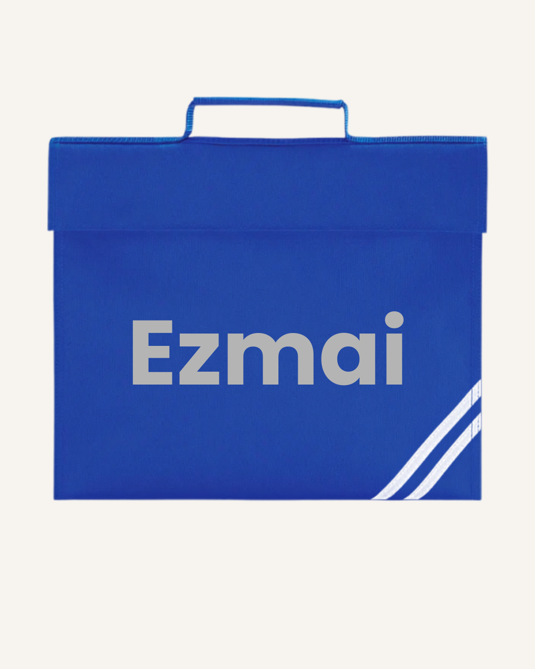A royal blue Ezmai personalised book bag
with a top handle, featuring the name in grey text and two diagonal white stripes in the bottom right corner, set against a light cream background.