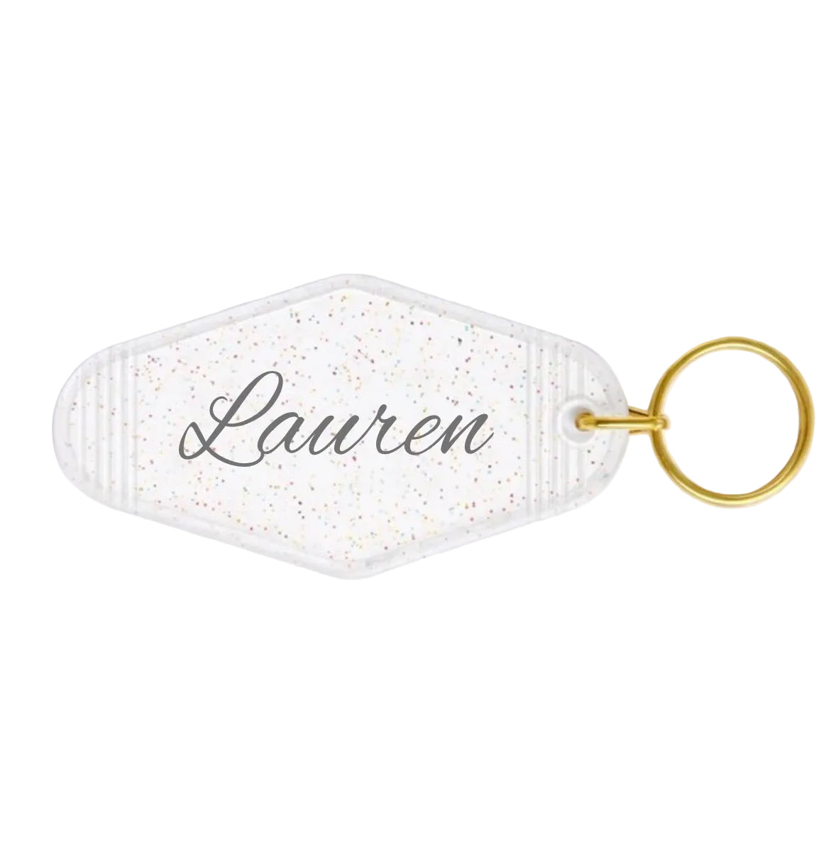 A personalized hexagonal acrylic keychain with a white background, subtle multicolor glitter speckles, the name 'Lauren' printed in gray script, and a gold split ring, displayed on a white fabric background.