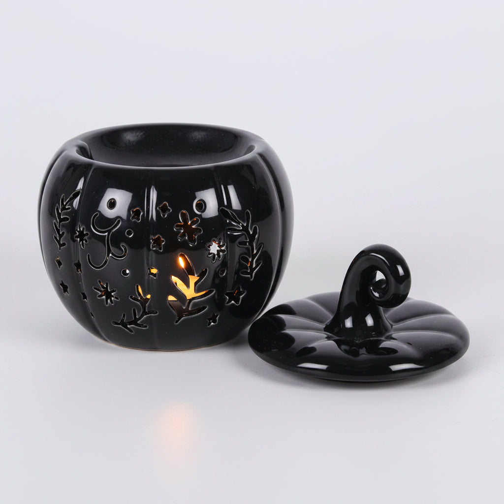 black pumpkin shaped oil burner with lid on a grey background
