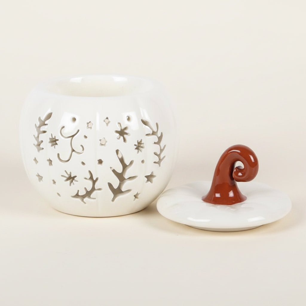 Ceramic pumpkin oil burner with decorative lid on a white background