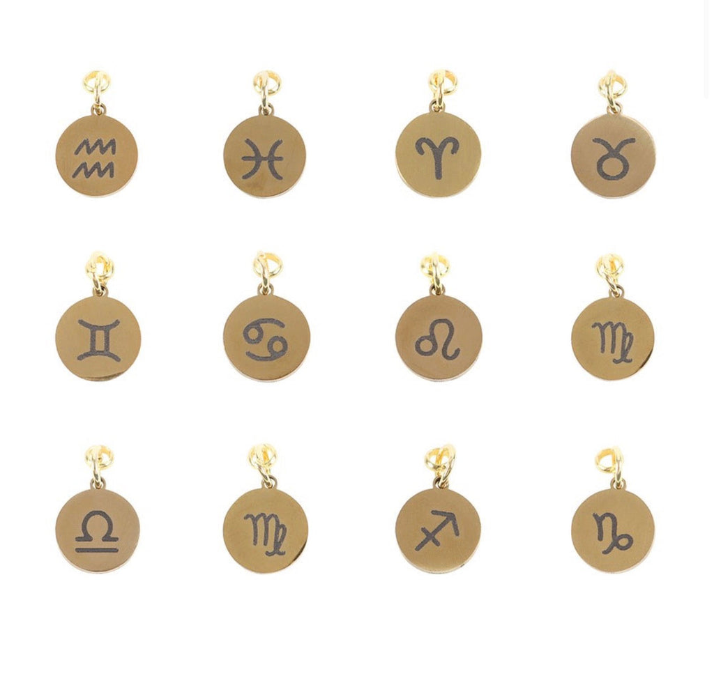 Set of gold and bronze zodiac charm pendants on a white background