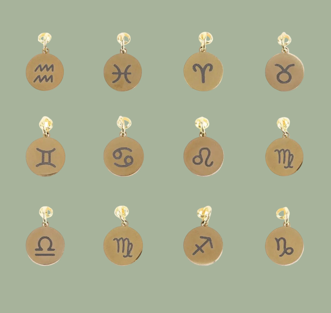 Set of gold and bronze zodiac charm pendants on a white background