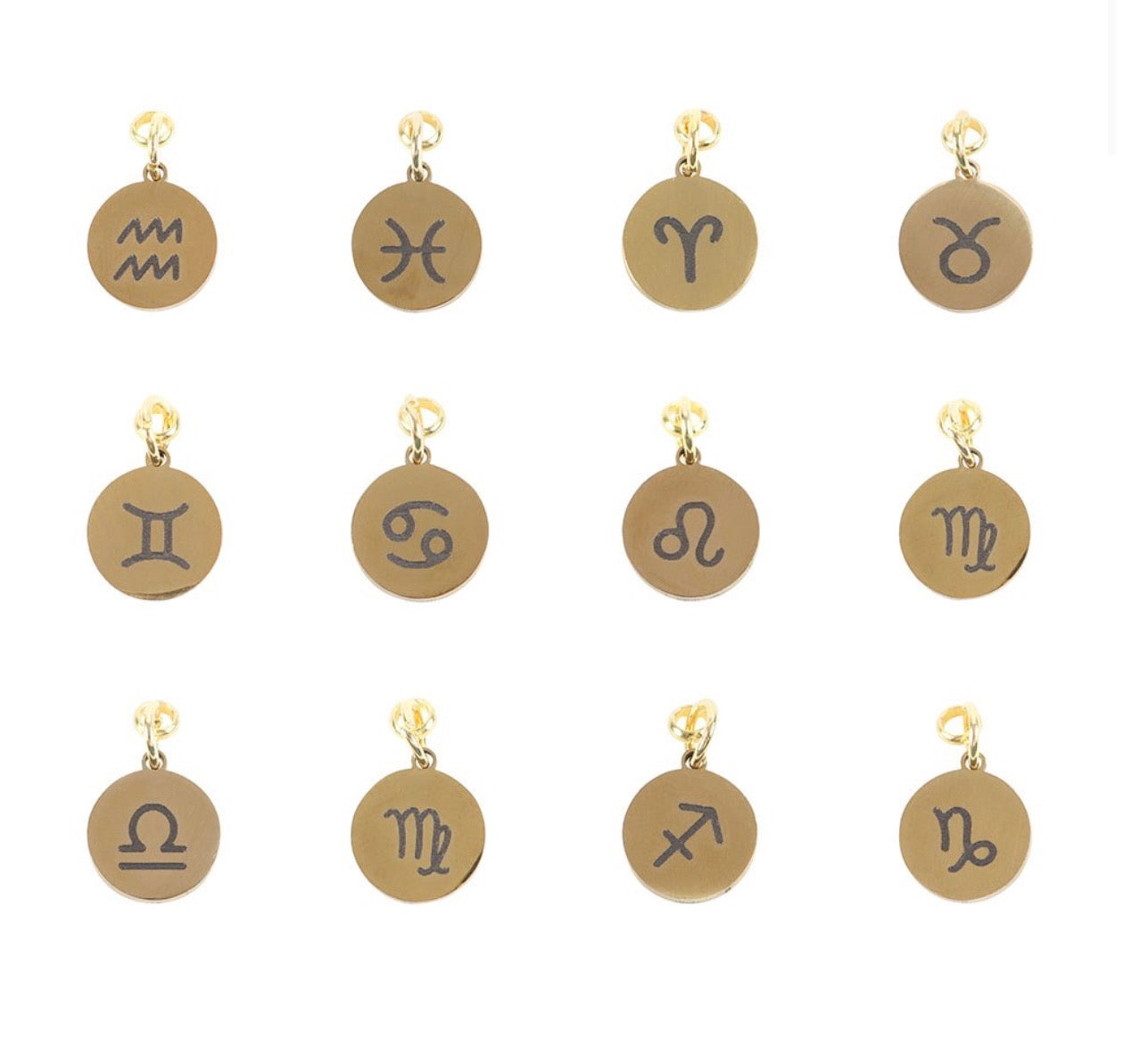 Set of gold and bronze zodiac charm pendants on a white background