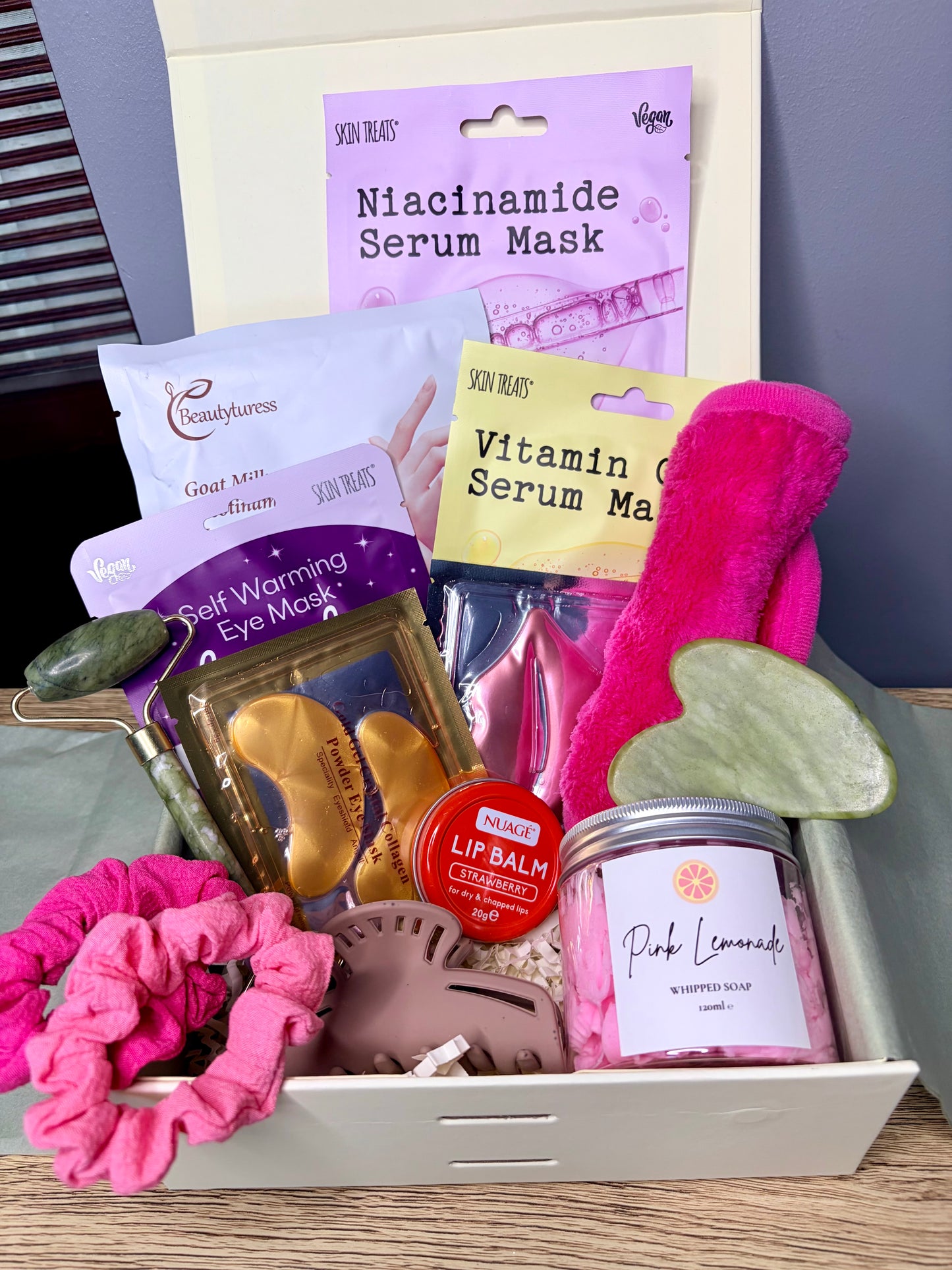 Curated skincare gift box including face masks, whipped soap, hair accessories, lip balm, facial tools and face cloth in gift box.