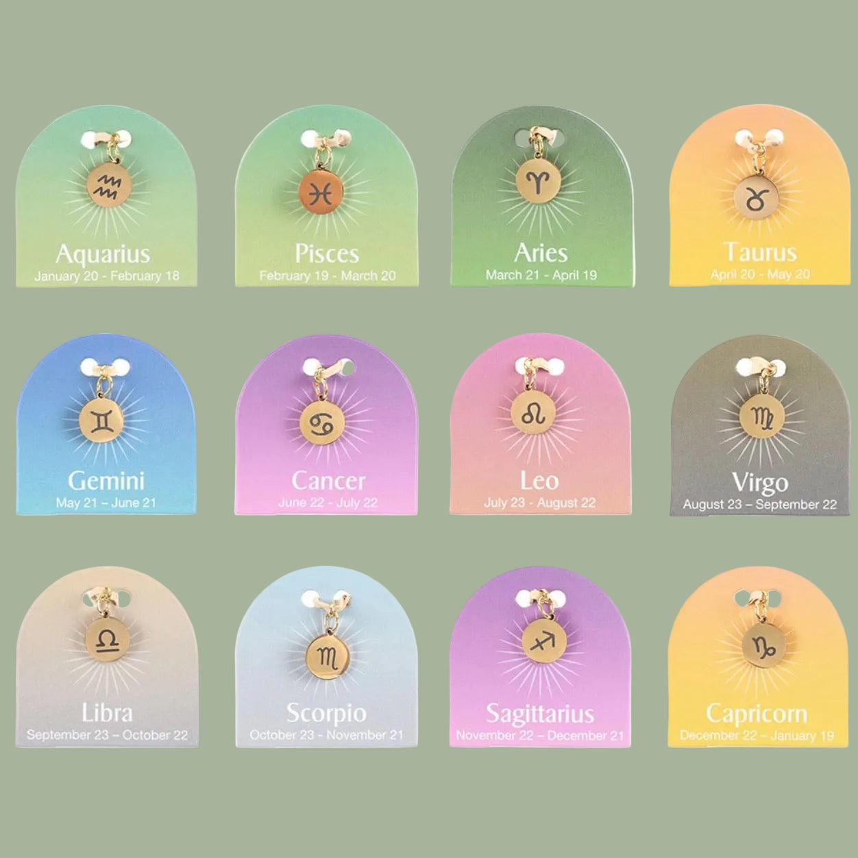 Set of zodiac charm pendants on display with corresponding dates.