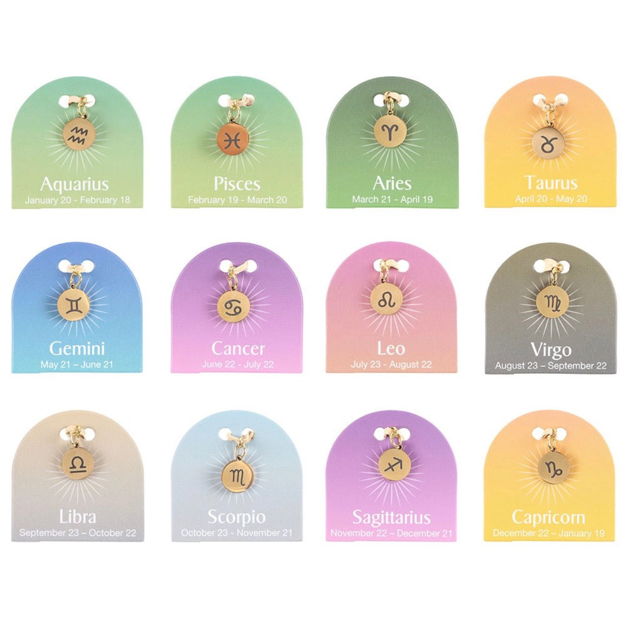 Set of zodiac charm pendants on display with corresponding dates.