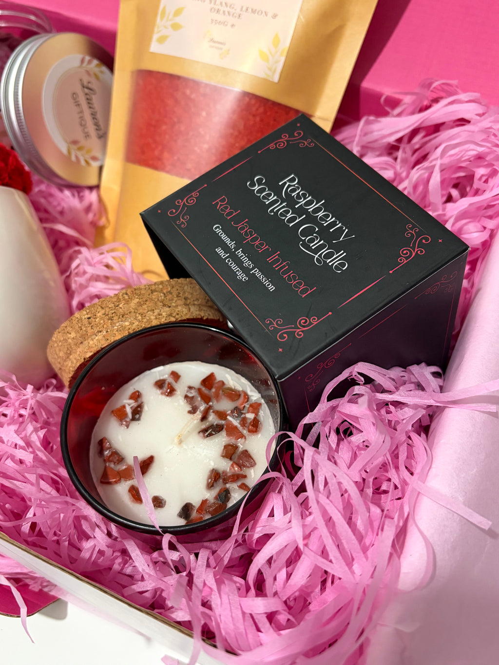 close up of raspberry scented candle infused with red jasper