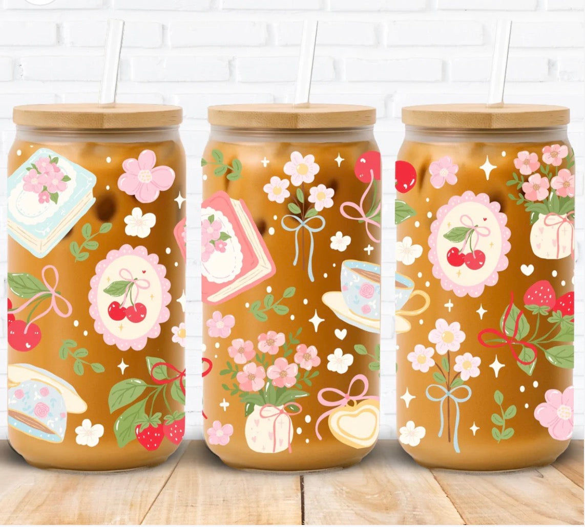 Three decorative glasses with floral and cherry designs on a wooden surface.