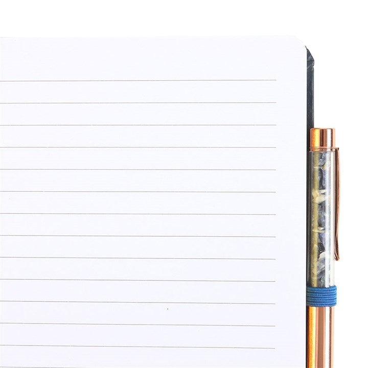 Clear pen with bronze accents on a lined notebook page