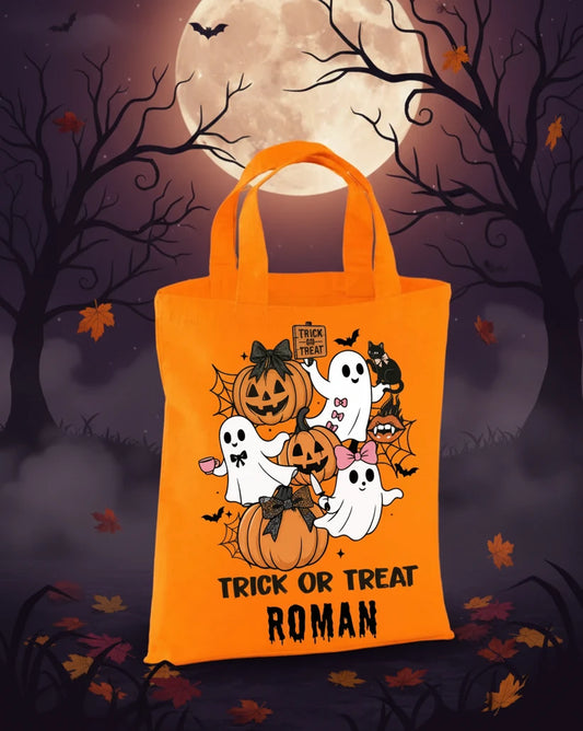 Orange mini tote bag with hallow design and ‘trick or treat’ with the name Roman on a Halloween evening background with the moon. 