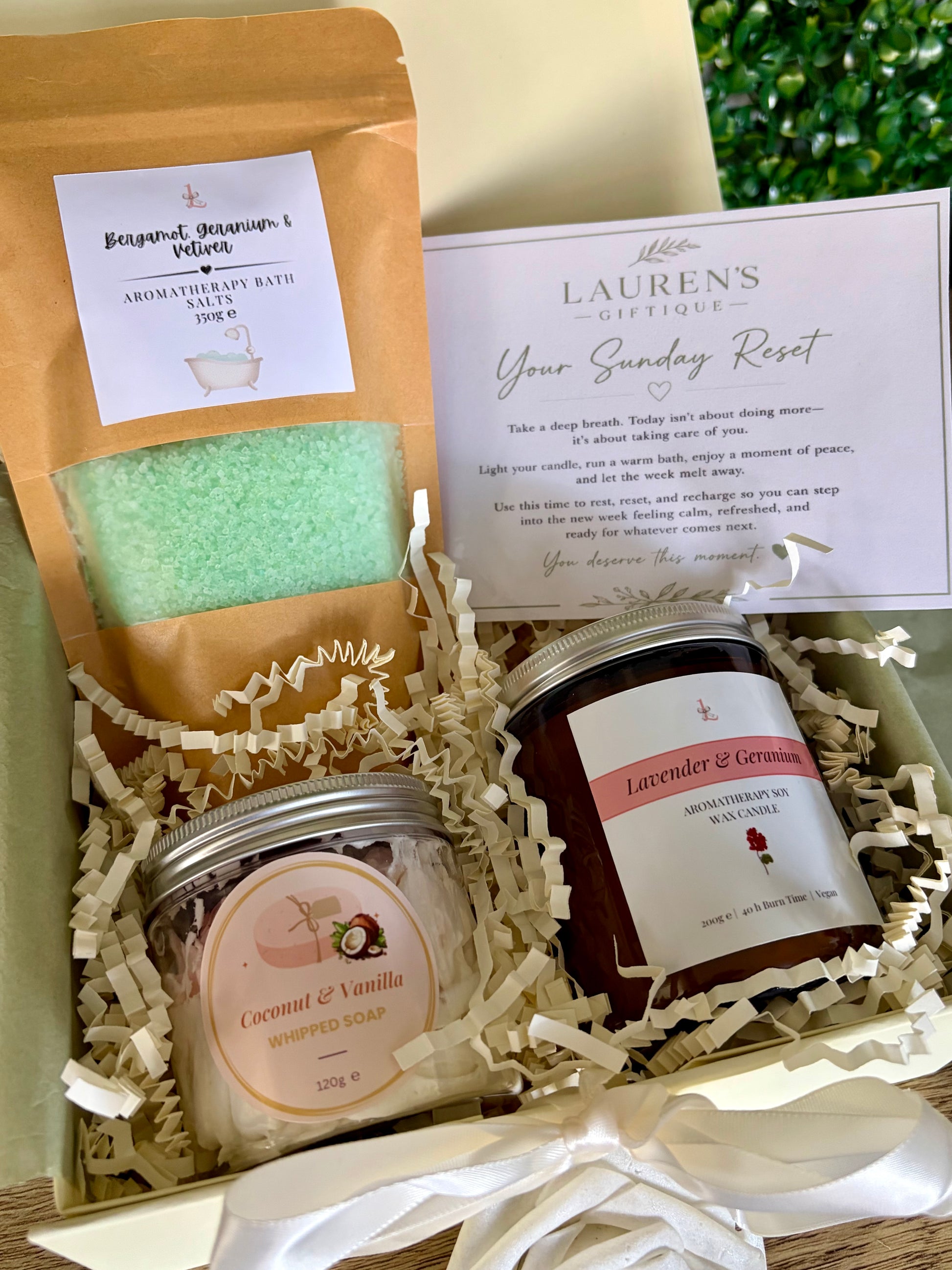 Bergamot, Geranium & Vetiver bath potion in kraft bag, whipped soap, aromatherapy candle in Lavender & Geranium with a 'Sunday Reset' card on a ivory gift box and shred.
