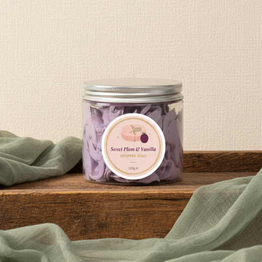 Jar of Sweet Plum & Vanilla whipped soap with a lid removed on a lilac background