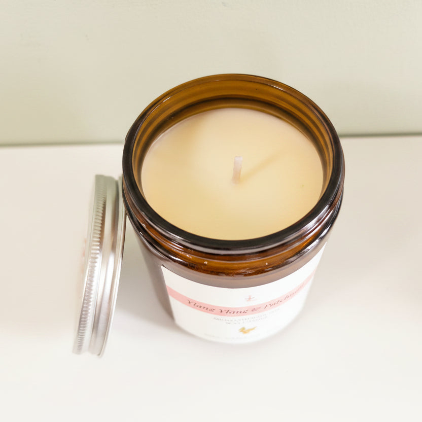 Candle in a glass jar with a label on a neutral background