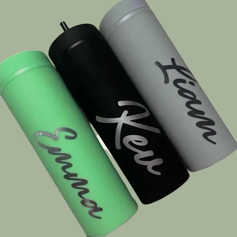 Three insulated tumblers in green, black, and gray with names on them.