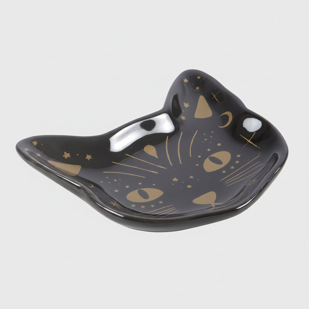 Black cat-shaped dish with gold designs on a grey background