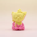 Yellow and pink cat-shaped bath bomb on a pastel background