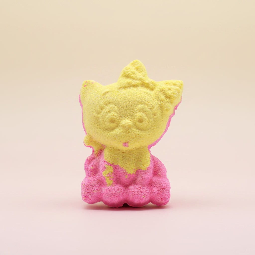 Yellow and pink cat-shaped bath bomb on a pastel background