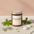 Jar of Clary Sage & Peppermint candle on a pink and white background