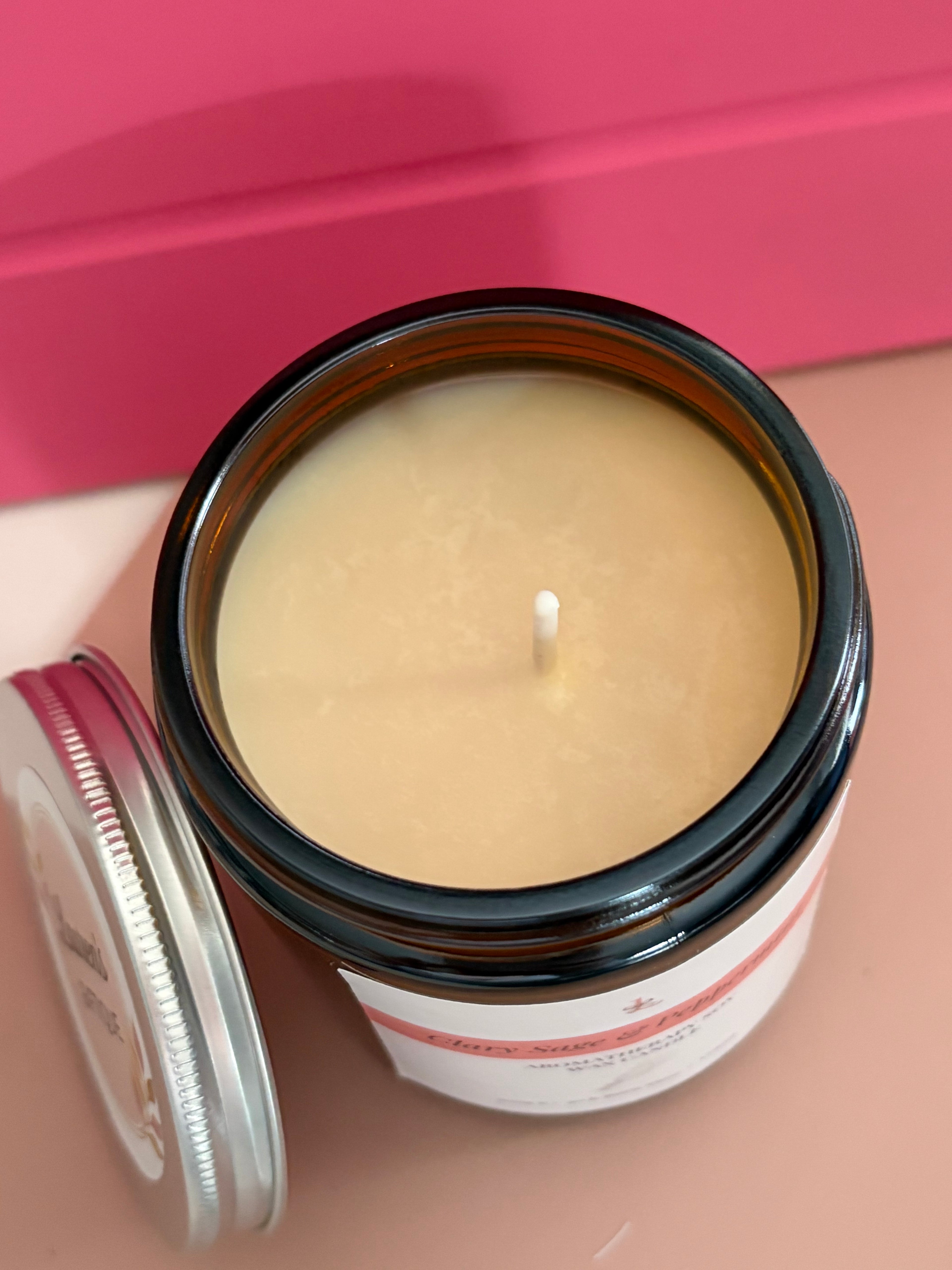 Candle in an open jar with a pink background