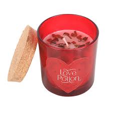 Red candle in a glass container with a cork lid, featuring 'Love Potion' text on a white background.