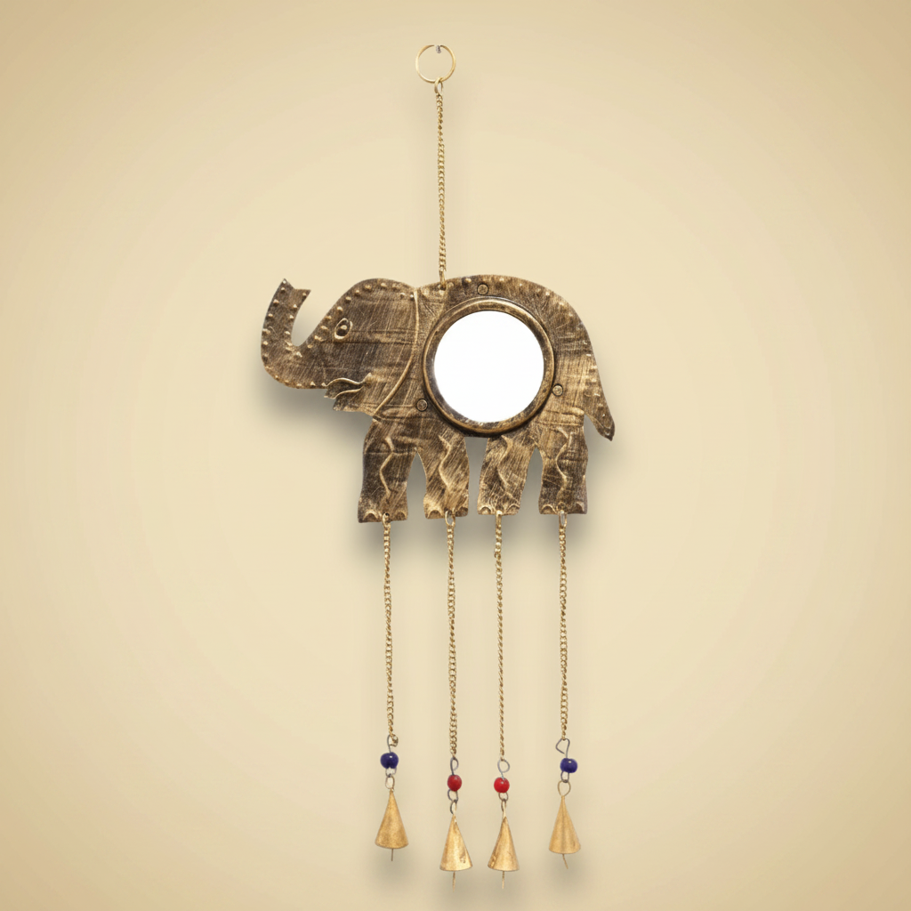 Decorative brass elephant with hanging bells on a light gold background