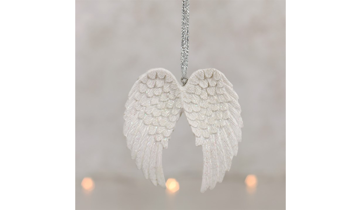 White angel wings hanging against a light gray background