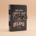 Decorative notebook with 'Never give up on your dreams' text on a brown background