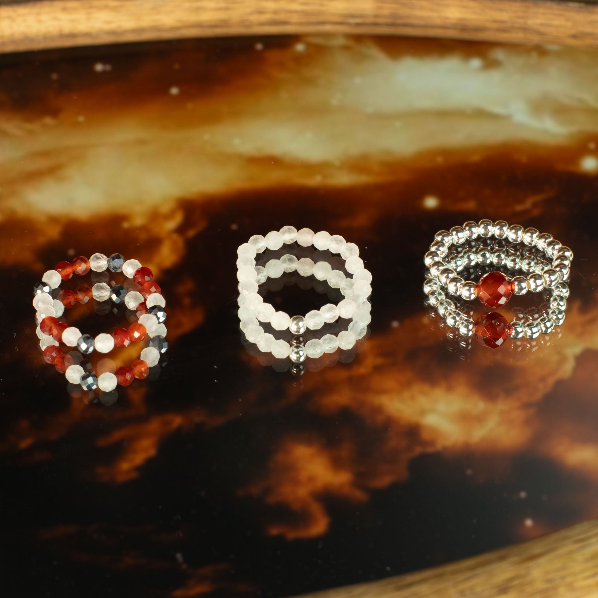 Three beaded rings on a reflective surface