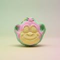 Colorful monkey-shaped bath bomb on a pastel background