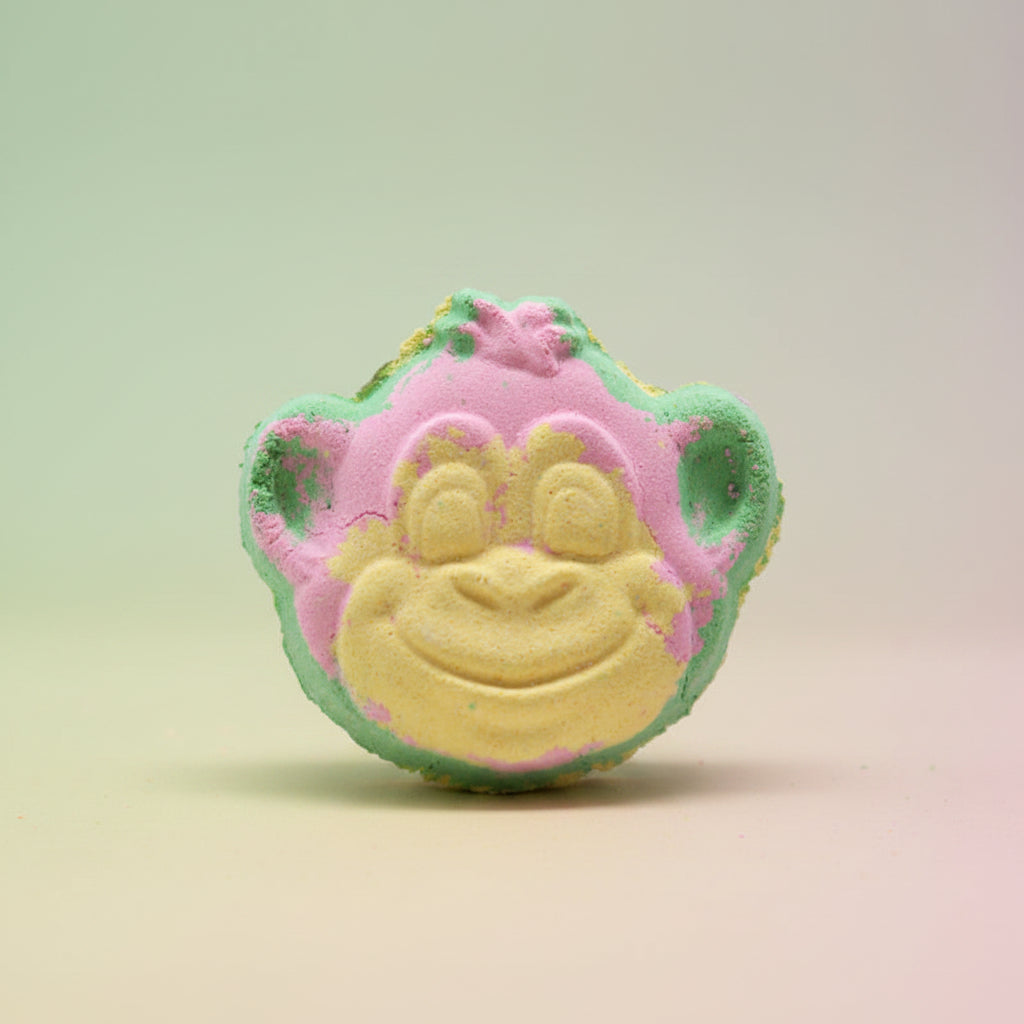 Colorful monkey-shaped bath bomb on a pastel background