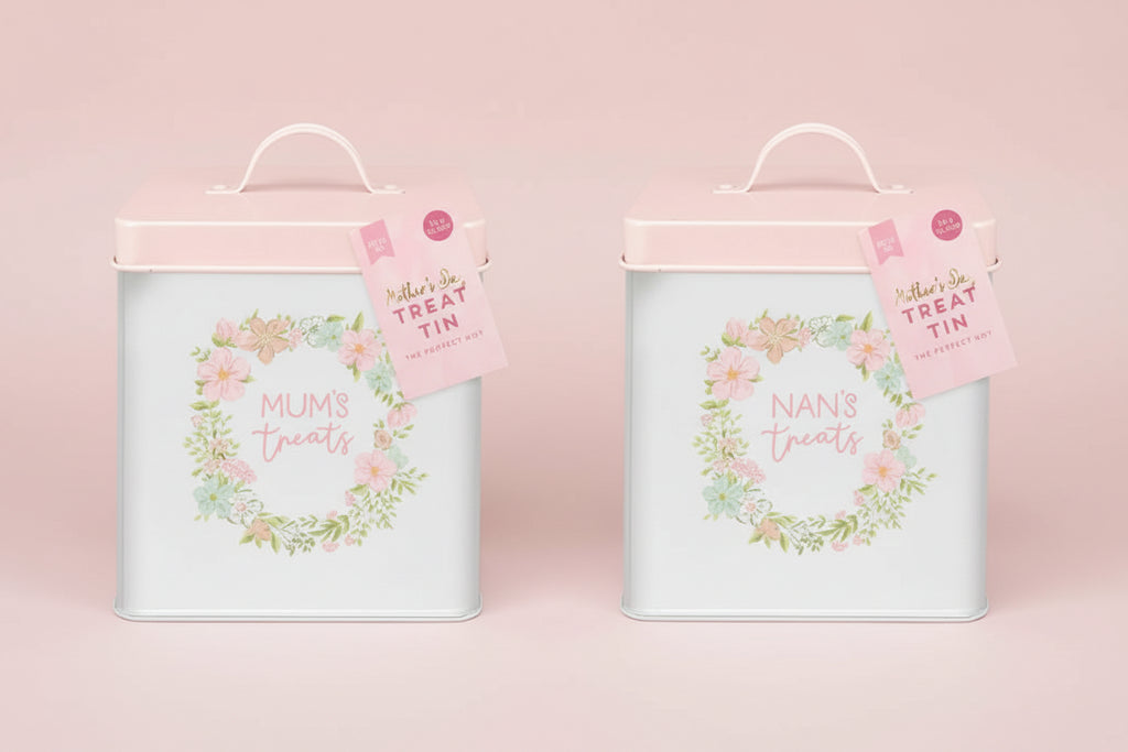 Two treat tins labeled 'Mums' treats' and 'Nans' treats' with floral designs on a light pink background.