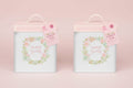Two treat tins labeled 'Mums' treats' and 'Nans' treats' with floral designs on a light pink background.