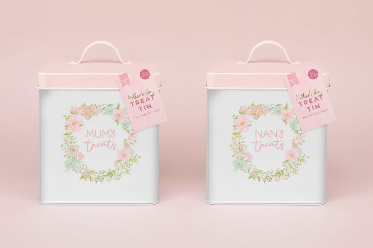 Two treat tins labeled 'Mums' treats' and 'Nans' treats' with floral designs on a light pink background.