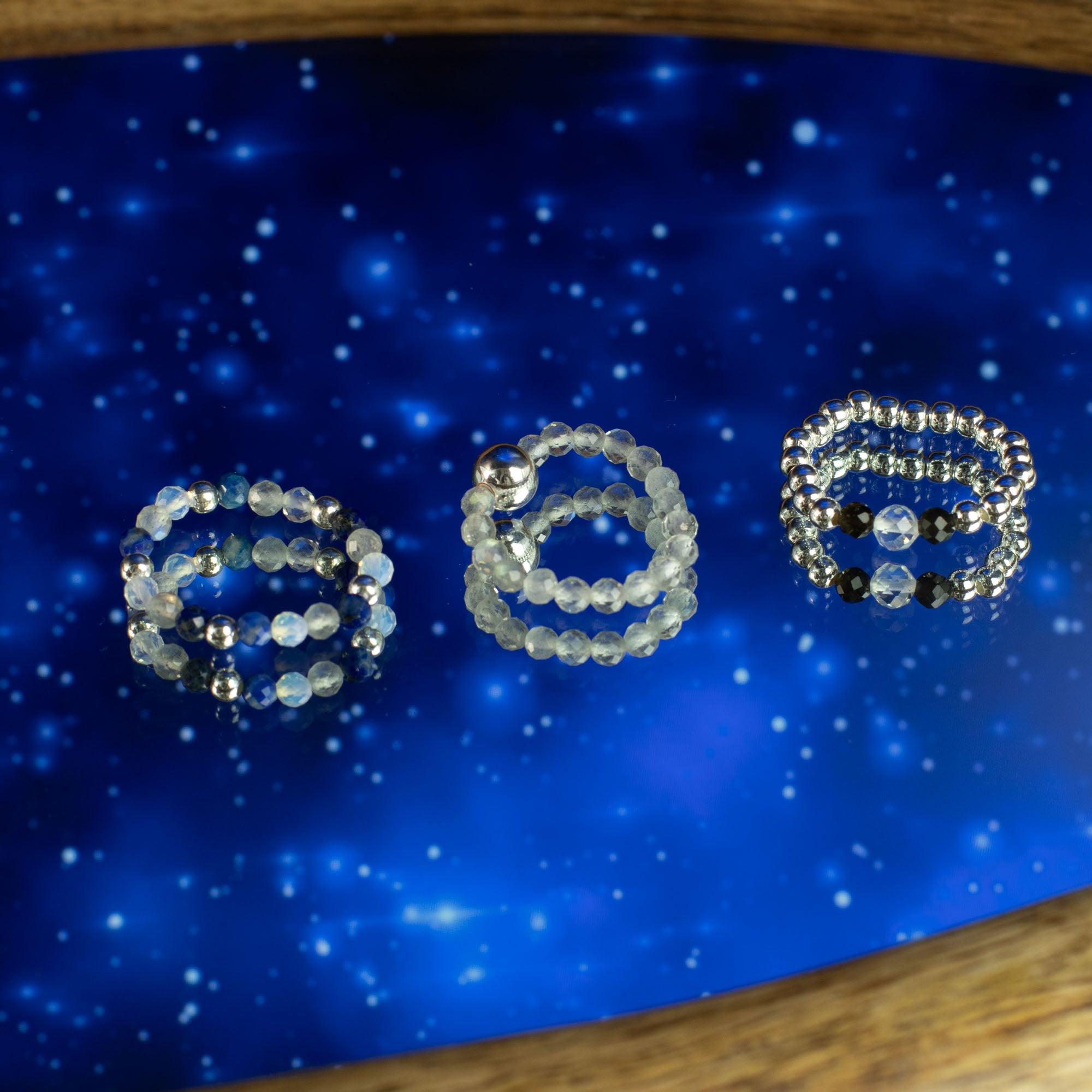 Three gemstone rings on a blue lighting background