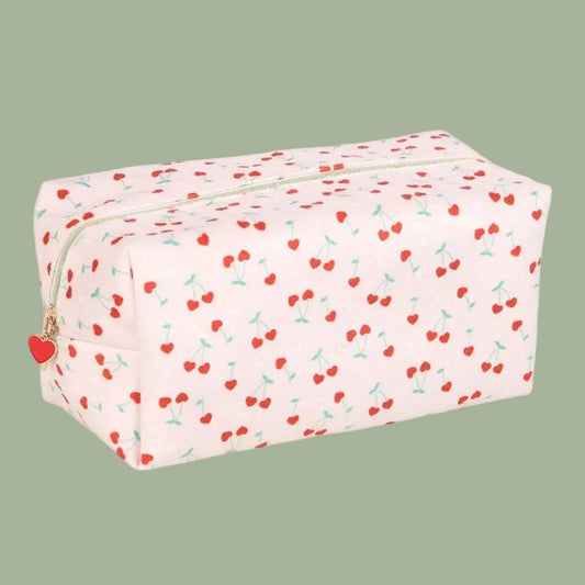 A rectangular zippered pouch with a light pink background covered in a red cherry print, featuring a small red heart charm on the zipper pull.