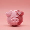 Pink pig-shaped bath bomb on a red/pink background