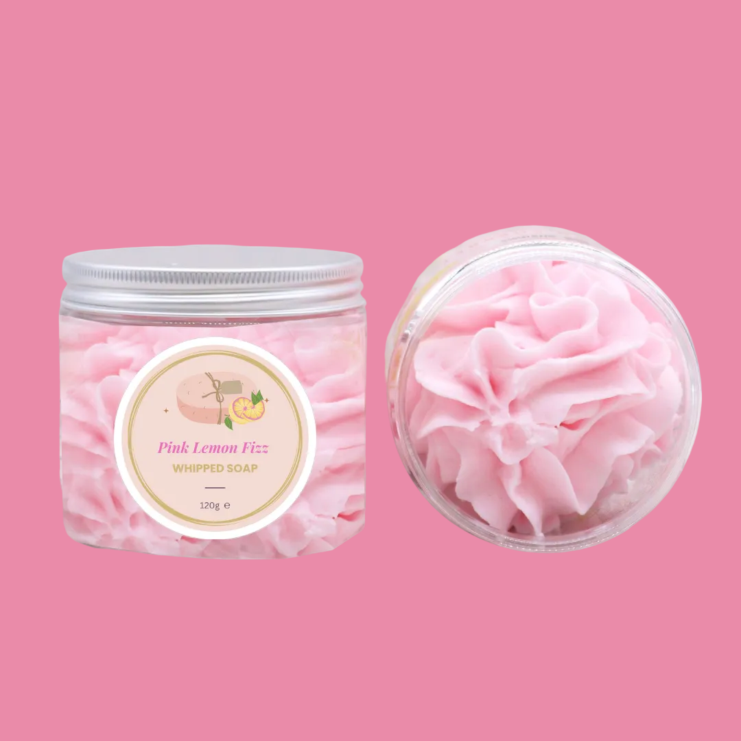 Pink lemon fizz whipped soap in a container with a silver lid on a pink background