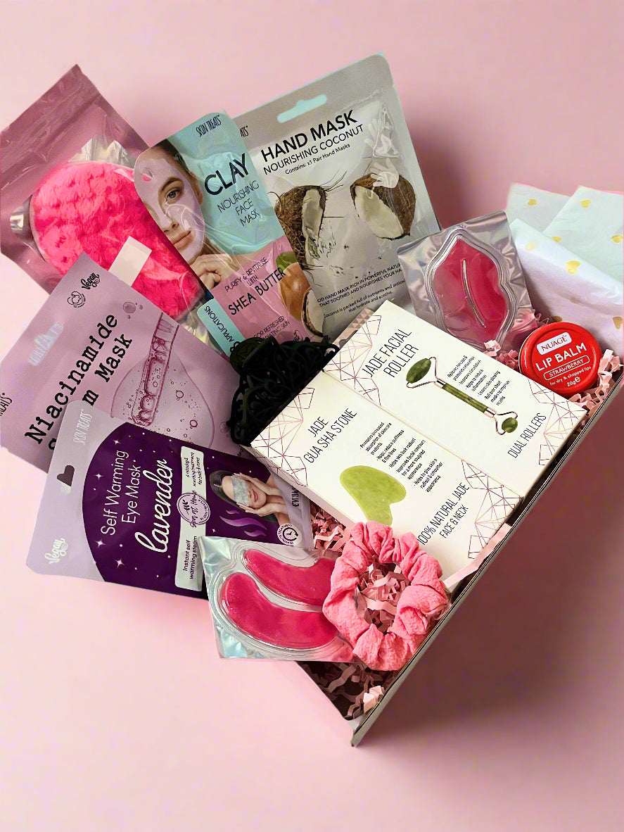 Assorted self-care products including masks and lip balm in a box on a light surface.