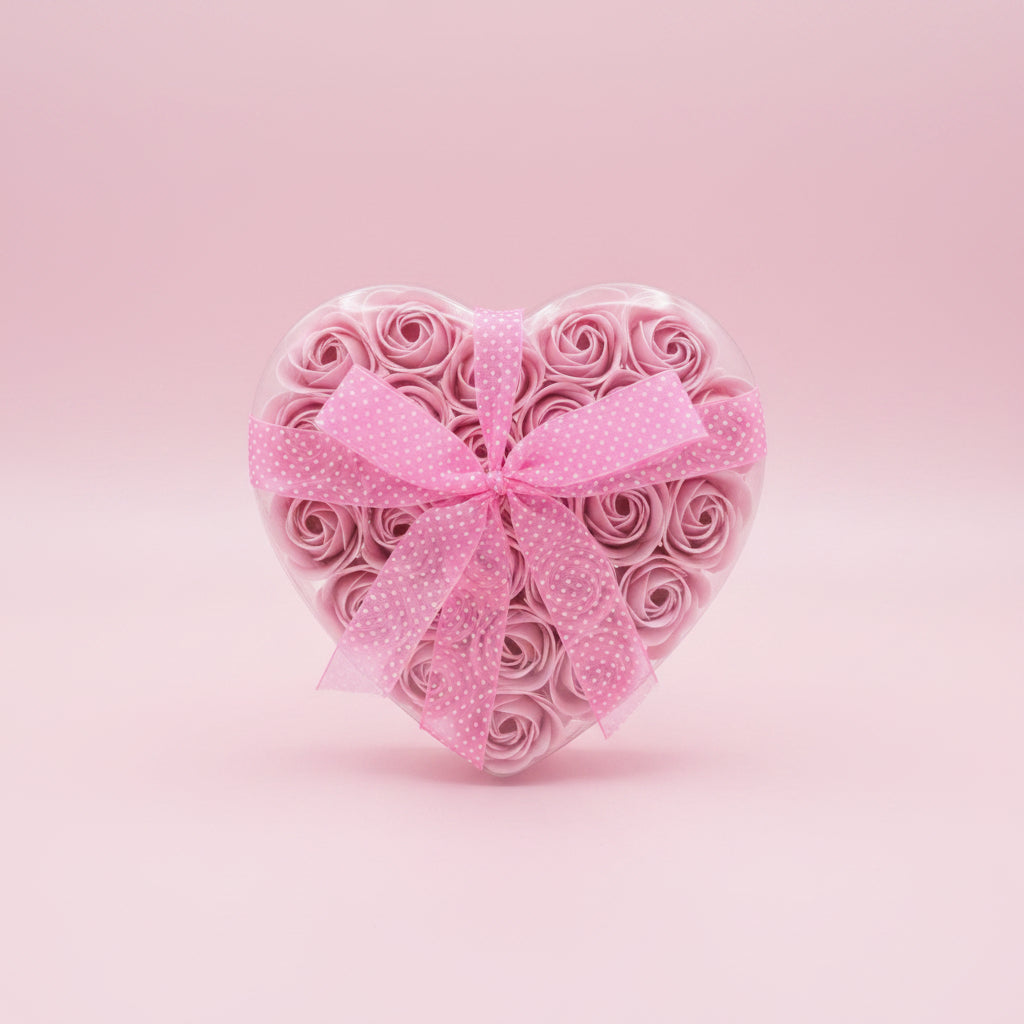 Heart-shaped arrangement of pink roses with a polka dot ribbon on a pink background