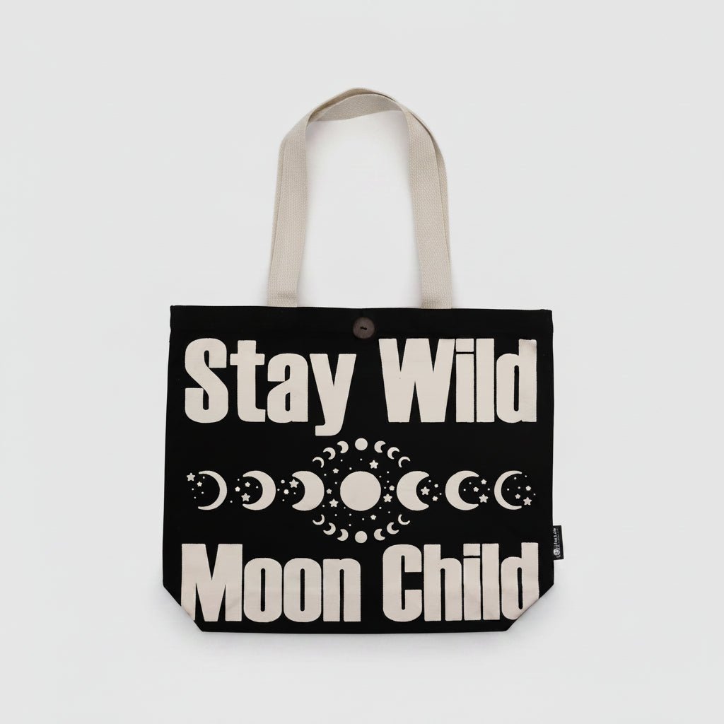 Black tote bag with 'Stay Wild Moon Child' text and moon phases on a white background