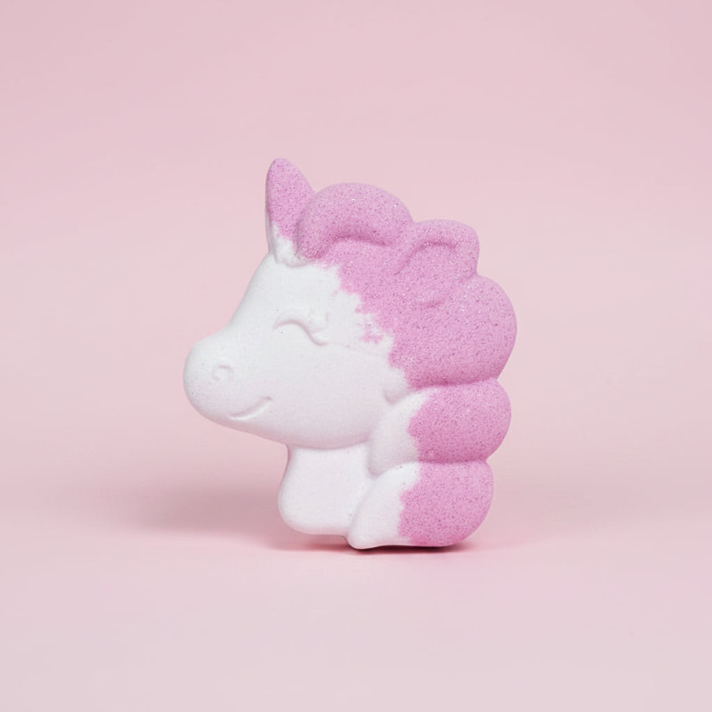 Unicorn-shaped bath bomb with pink and white colors on a pink background