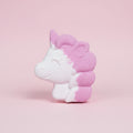 Unicorn-shaped bath bomb with pink and white colors on a pink background