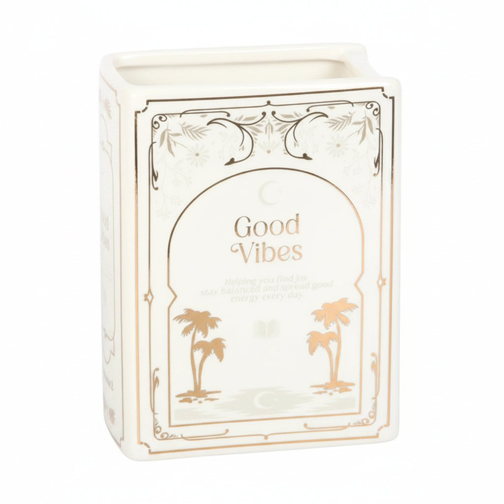 white book vase with text 'good vibes' and gold palm trees on a grey background
