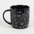 Black mug with mystical design on a grey background